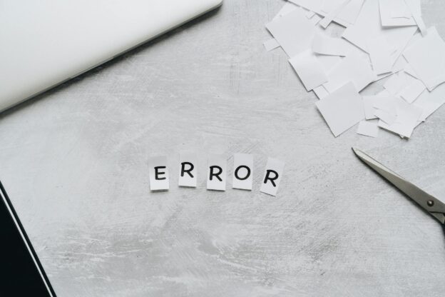 Creative concept showing the word 'error' with cut out letters on a table with scissors and paper.